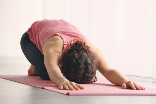 Sportig ung kvinna som tränar yoga inomhus — Stockfoto