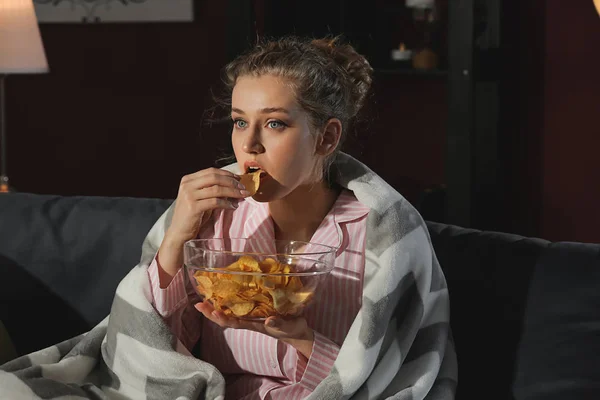 Beautiful young woman eating unhealthy food at night — Stock Photo, Image
