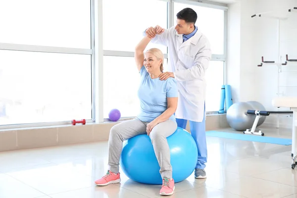 Fysiotherapeut werken met volwassen patiënt in revalidatiecentrum — Stockfoto