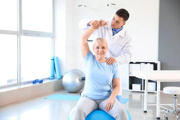 Physiotherapist working with mature patient in rehabilitation center — Stock Photo, Image