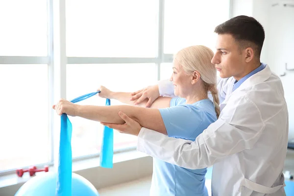 Fysiotherapeut werken met volwassen patiënt in revalidatiecentrum — Stockfoto