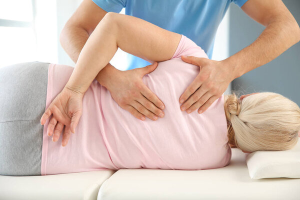 Физиотерапевт, работающий со зрелым пациентом в реабилитационном центре
