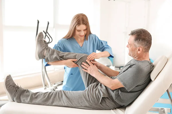 Physiotherapist working with mature patient in rehabilitation center — Stock Photo, Image