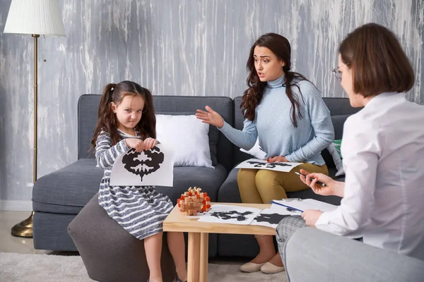 Stressed mother with naughty little daughter in psychologist\'s office