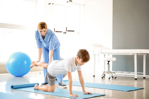 Fisioterapeuta trabajando con un niño pequeño en un centro de rehabilitación — Foto de Stock