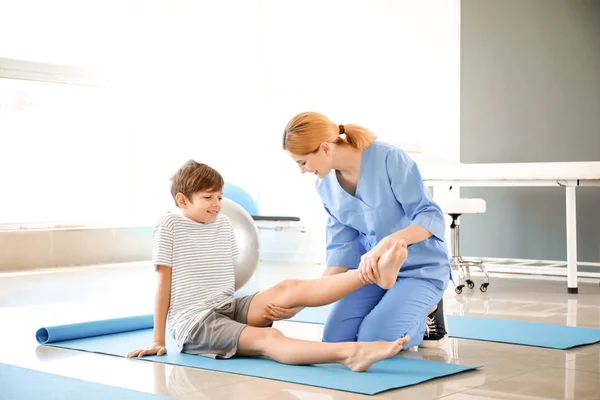 Fisioterapeuta trabajando con un niño pequeño en un centro de rehabilitación — Foto de Stock