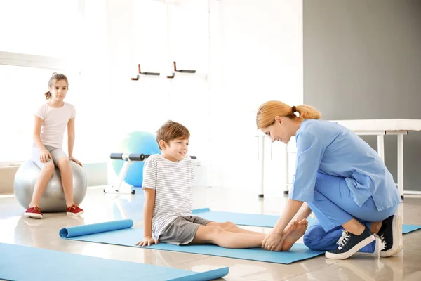 물리 치료사는 재활 센터에서 어린 소년과 함께 일하고 있습니다. — 스톡 사진