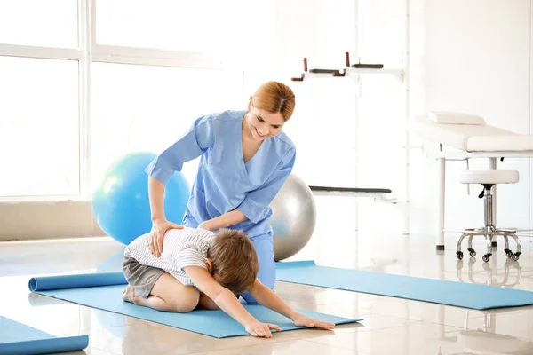 Fisioterapeuta trabajando con un niño pequeño en un centro de rehabilitación —  Fotos de Stock