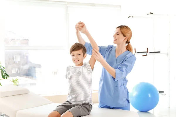 Fyzioterapeutka pracující s malým chlapcem v rehabilitačním centru — Stock fotografie