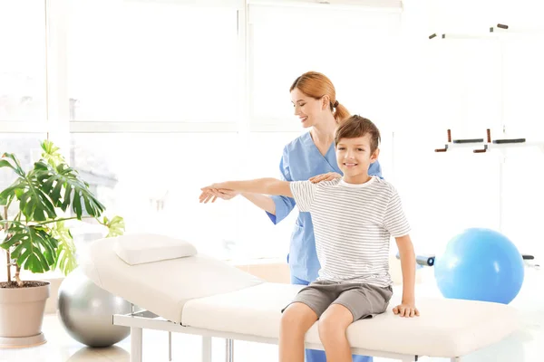 Physiotherapist working with little boy in rehabilitation center — Stock Photo, Image