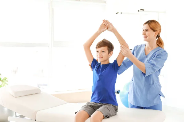 Fisioterapeuta trabalhando com menino em centro de reabilitação — Fotografia de Stock