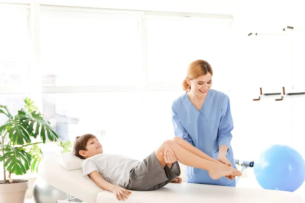 Physiotherapist working with little boy in rehabilitation center — Stock Photo, Image