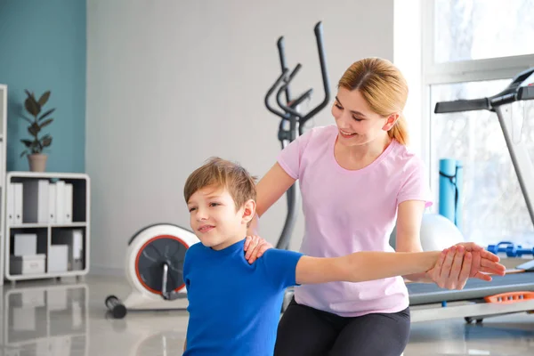 Physiotherapist working with little boy in rehabilitation center — Stock Photo, Image