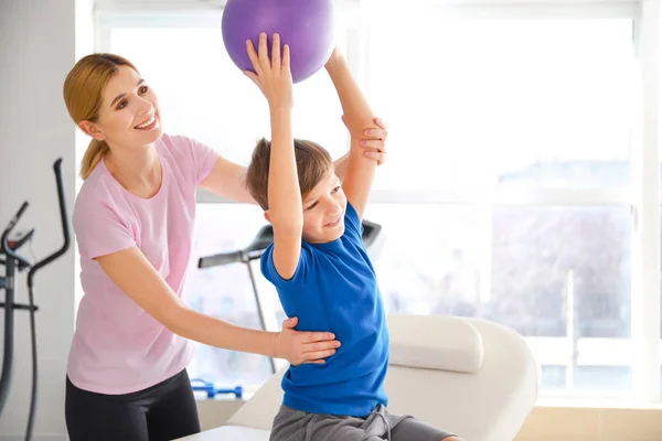 Physiotherapist working with little boy in rehabilitation center — Stock Photo, Image