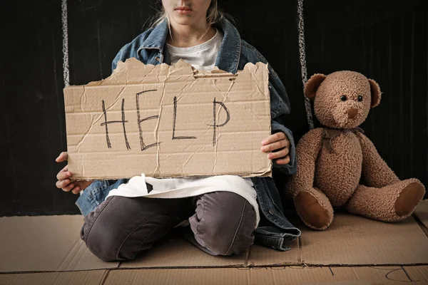 Homeless little girl begging for help near dark wall — Stock Photo, Image