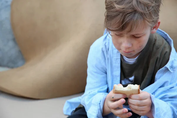 Niño sin hogar con pan al aire libre — Foto de Stock