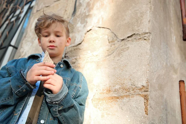 Бездомный мальчик ест хлеб на открытом воздухе — стоковое фото