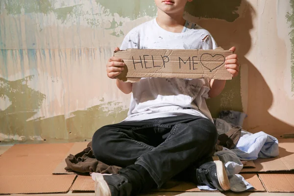 壁の近くで助けを求めるホームレスの少年 — ストック写真