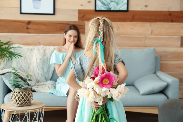 Little girl hiding bouquet of beautiful tulips for her mother behind back — Stock Photo, Image