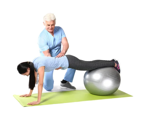 Mature physiotherapist working with young Asian woman on white background — Stock Photo, Image