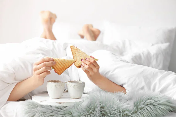 Nettes junges Paar frühstückt im Bett — Stockfoto