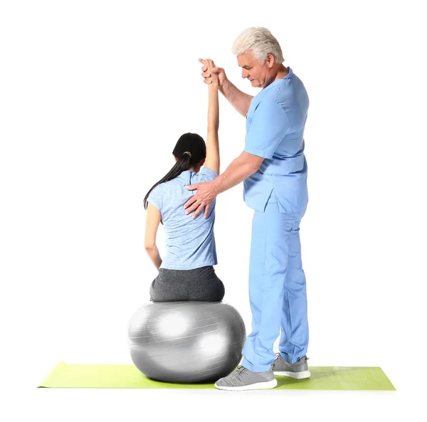 Mature physiotherapist working with young Asian woman on white background — Stock Photo, Image