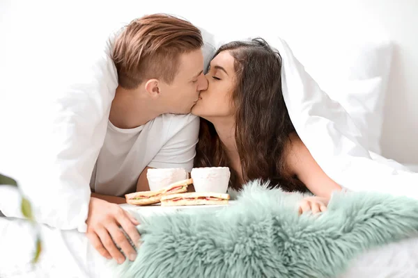 Nettes junges Paar frühstückt im Bett — Stockfoto