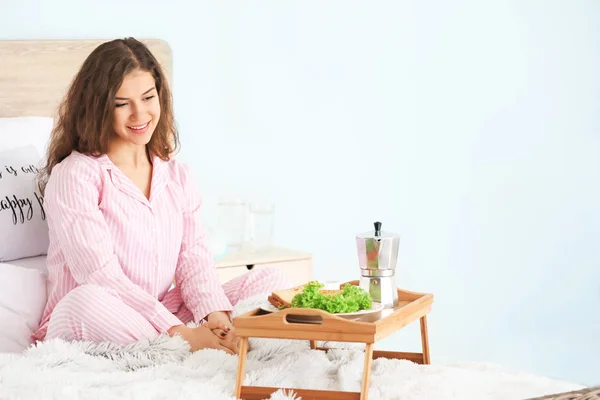 Beautiful young woman having breakfast in bed — Stock Photo, Image