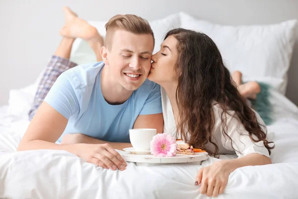 Nettes junges Paar frühstückt im Bett — Stockfoto