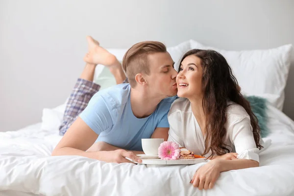 Bonito jovem casal tomando café da manhã na cama — Fotografia de Stock