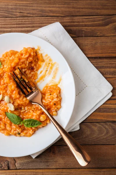 Piatto con risotto gustoso sul tavolo di legno — Foto Stock