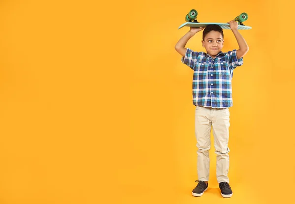 Πορτρέτο του χαριτωμένο μικρό αγόρι με σκέιτμπορντ στο χρώμα φόντο — Φωτογραφία Αρχείου