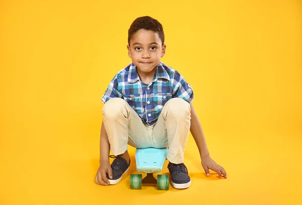 Portret van schattige kleine jongen met skateboard op kleur achtergrond — Stockfoto