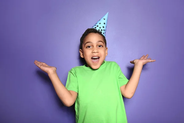 Portrait of cute little boy in party hat on color background — Stock Photo, Image