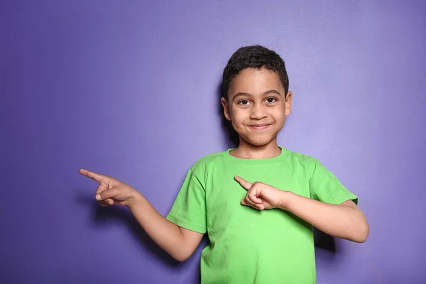 Retrato de lindo niño apuntando a algo en el fondo de color —  Fotos de Stock