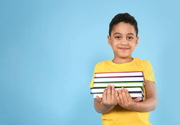 Portret Cute Little Boy z książek na kolorowym tle — Zdjęcie stockowe