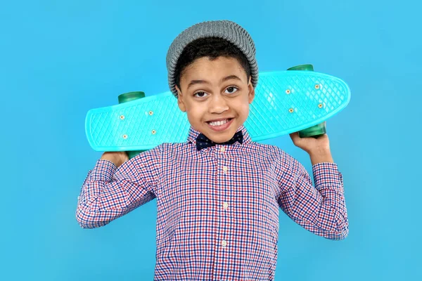 Ritratto di bambino fresco con skateboard su sfondo a colori — Foto Stock