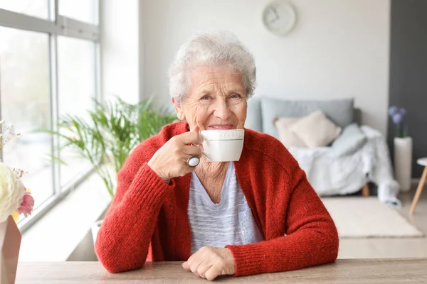 Idős nő teát iszik otthon. — Stock Fotó