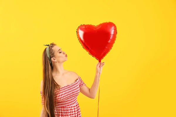 Mulher bonita com balão de ar em forma de coração sobre fundo de cor — Fotografia de Stock