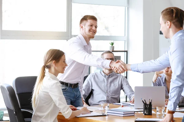 Young businessmen shaking hands at meeting in office — Stock Photo, Image