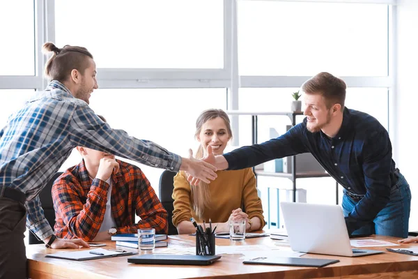 Unga affärsmän skakar hand vid mötet i ämbetet — Stockfoto