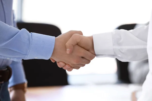 Young businessmen shaking hands at meeting in office, closeup — Stock Photo, Image