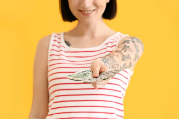 Beautiful young woman with dollar banknotes on color background, closeup