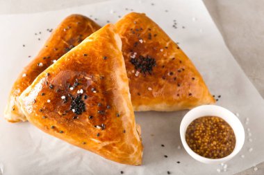 Parşömen üzerinde sos ile lezzetli samosas