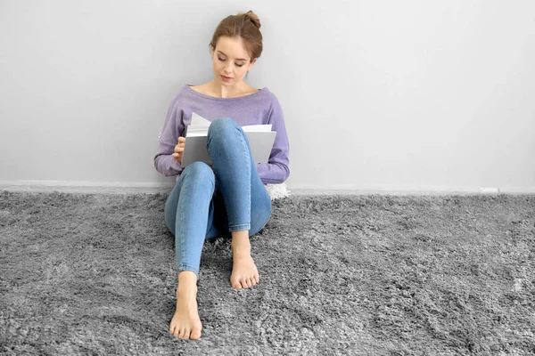 Jovem mulher ler livro em casa — Fotografia de Stock