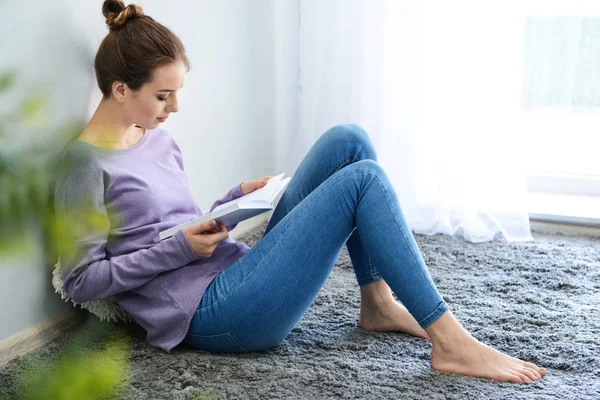 Hermosa joven leyendo libro en casa — Foto de Stock