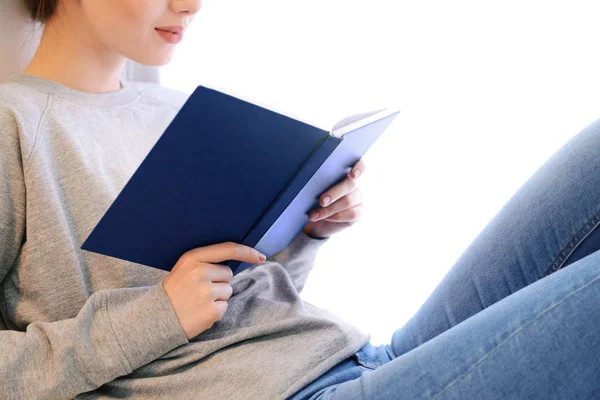 Krásná mladá žena čtení knihy doma — Stock fotografie