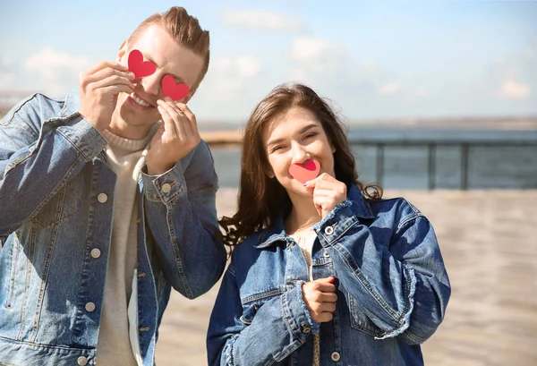 Feliz pareja joven con corazones de papel al aire libre —  Fotos de Stock