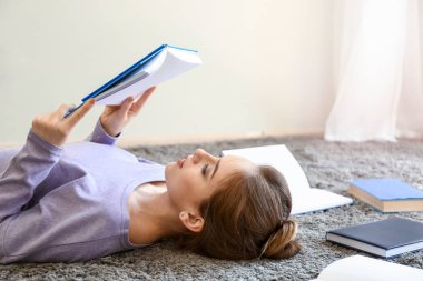 Evde kitap okuyan kız öğrenci