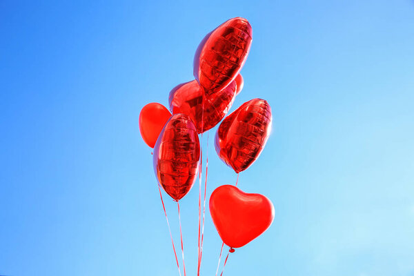 Heart shaped air balloons on blue sky background